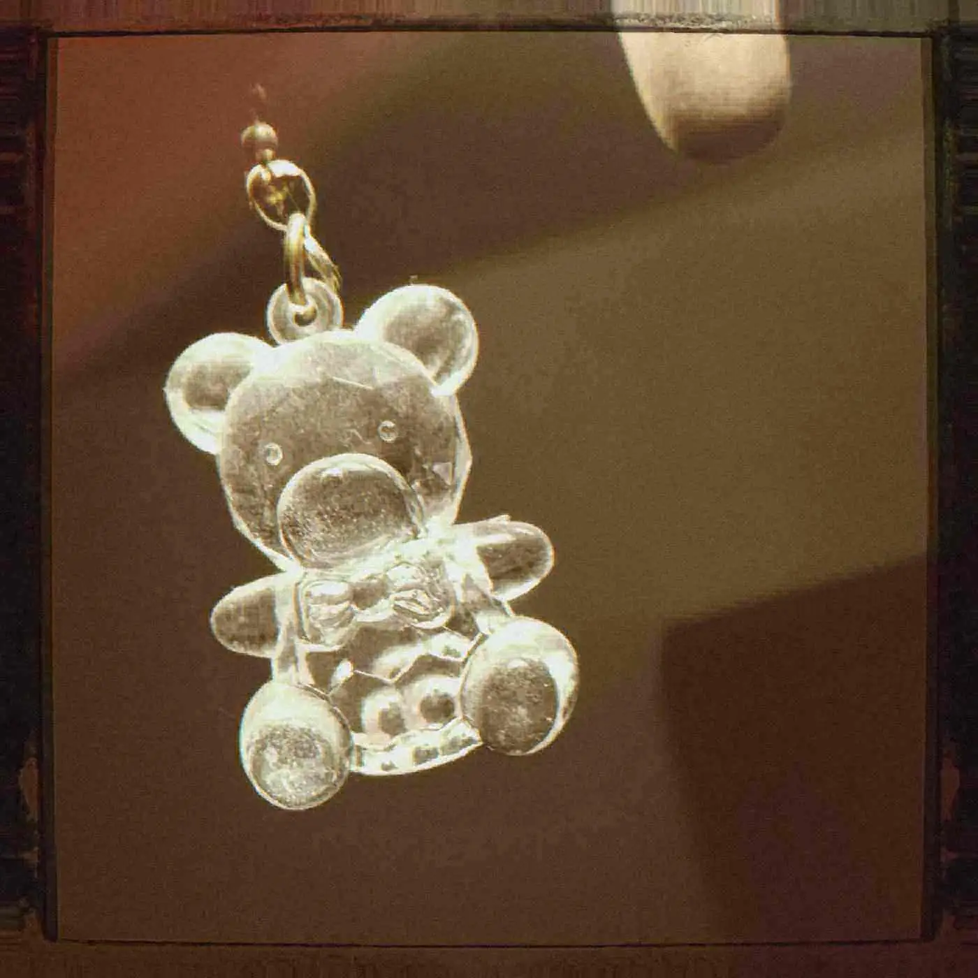 A clear plastic teddy charm. Photo by Michael Scialdone, CC BY 2.0.