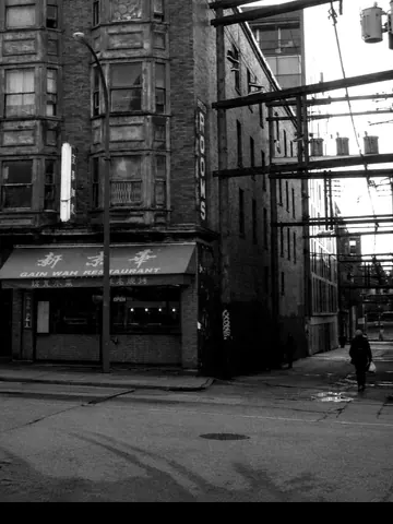 A wet Vancouver street at dusk. The coat walked out with nowhere to check it.