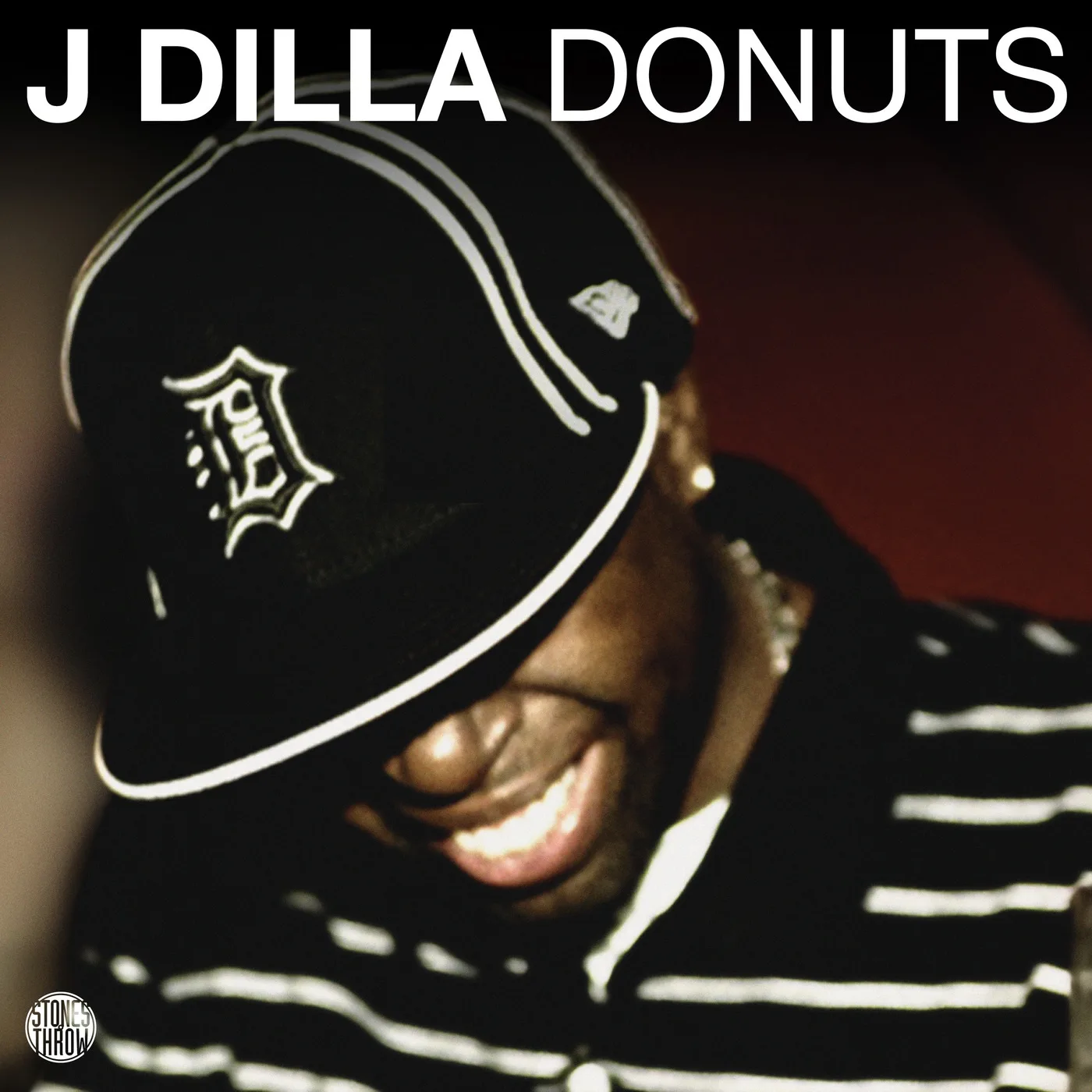 J Dilla Donuts album cover — smiling portrait in a Detroit D cap
